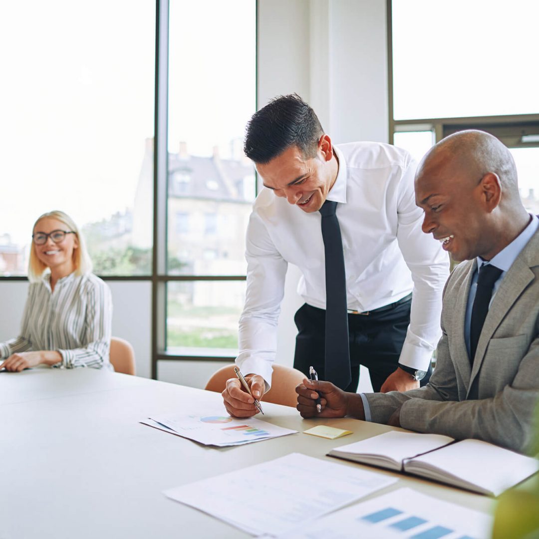 two-smiling-businessmen-discussing-paperwork-7YPYP9Q-1.jpg